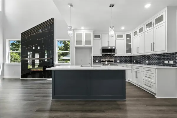 a kitchen with granite countertop a stove and cabinets