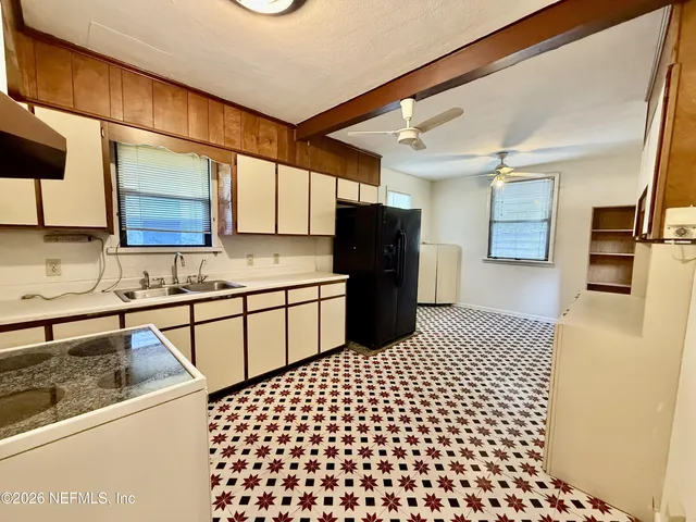 a kitchen with a sink a refrigerator and cabinets