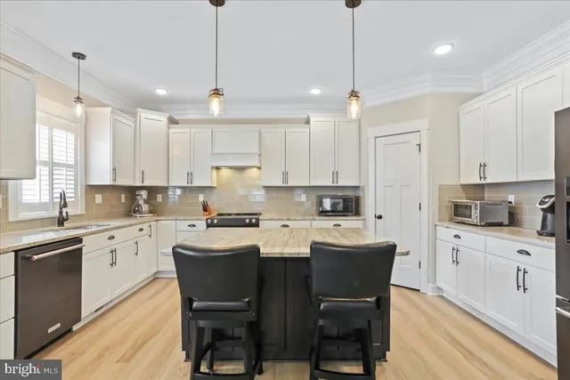 a kitchen with kitchen island granite countertop a center island a sink stainless steel appliances and cabinets