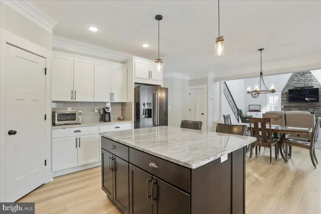 a kitchen with a table chairs sink and refrigerator