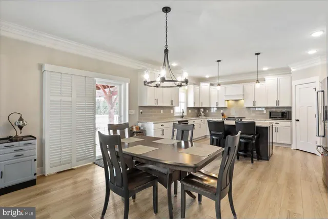 a dining room with stainless steel appliances kitchen island granite countertop a dining table chairs and stove