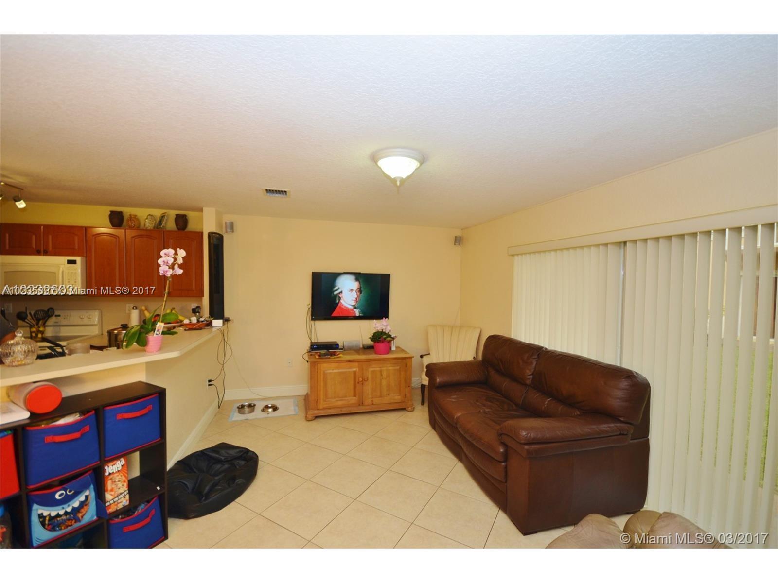 3153 Southwest 129th Terrace, Unit 161 Miramar, FL 33027 - Photo 12 of 17 a living room with furniture and a flat screen tv