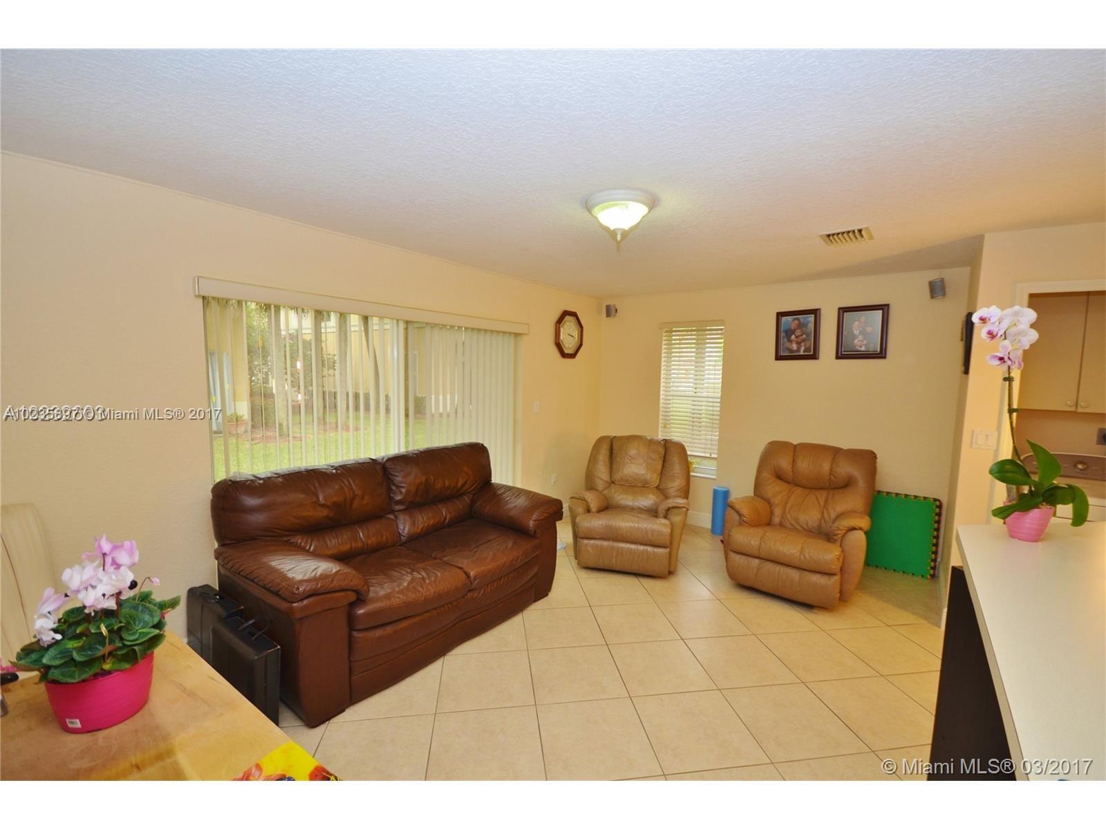 3153 Southwest 129th Terrace, Unit 161 Miramar, FL 33027 - Photo 13 of 17 a living room with furniture and flowers