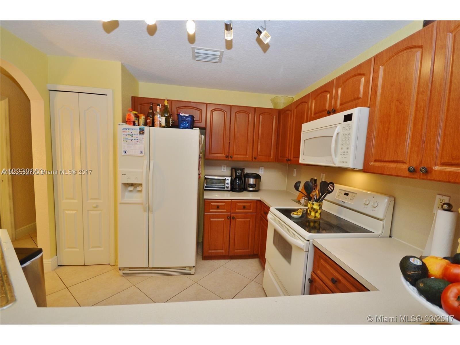 3153 Southwest 129th Terrace, Unit 161 Miramar, FL 33027 - Photo 3 of 17 a kitchen with a refrigerator a stove top oven a sink and dishwasher