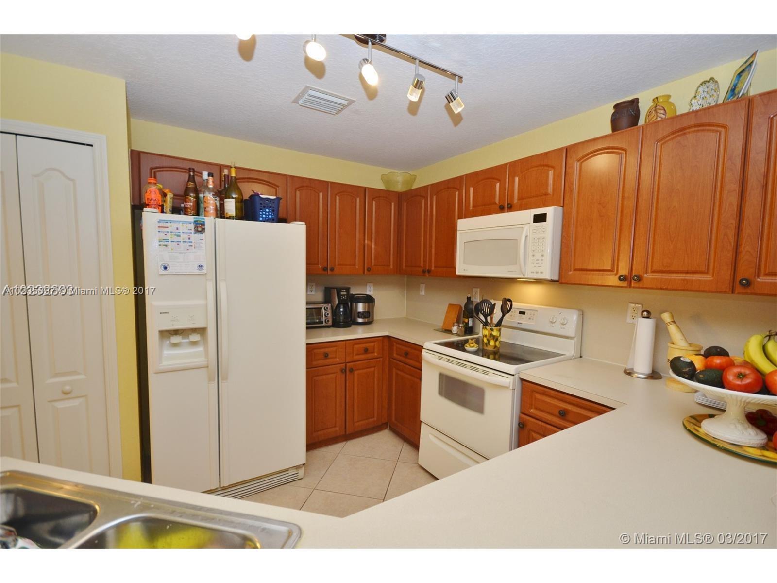 3153 Southwest 129th Terrace, Unit 161 Miramar, FL 33027 - Photo 4 of 17 a kitchen with stainless steel appliances granite countertop a refrigerator a sink dishwasher a stove with wooden cabinets