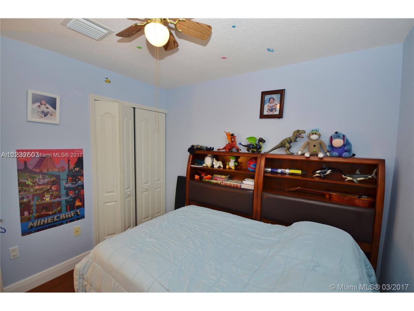 3153 Southwest 129th Terrace, Unit 161 Miramar, FL 33027 - Photo 8 of 17 a bedroom with a bed and a chandelier