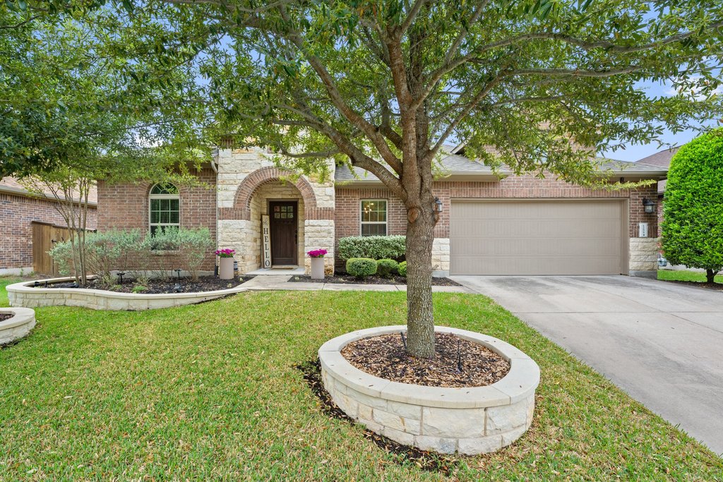 13808 Field Stream Lane Manor, TX 78653 - Photo 1 of 39 View of front facade featuring stone siding, an attached garage, concrete driveway, brick siding, and a front yard