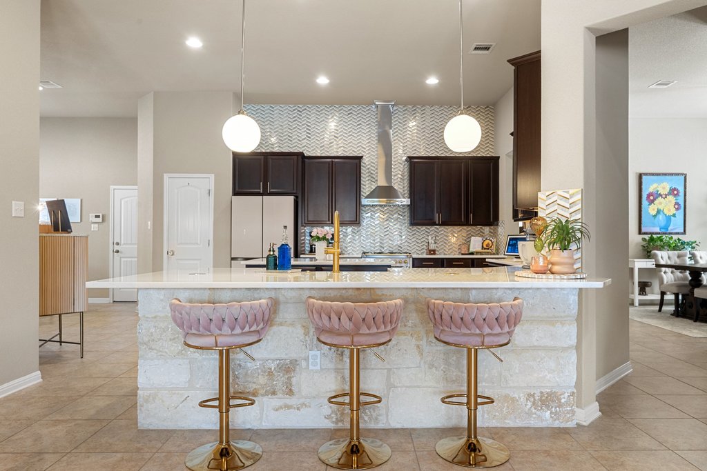 13808 Field Stream Lane Manor, TX 78653 - Photo 14 of 39 Kitchen featuring dark wood finish cabinets, tasteful backsplash, a peninsula, a breakfast bar area, and freestanding refrigerator