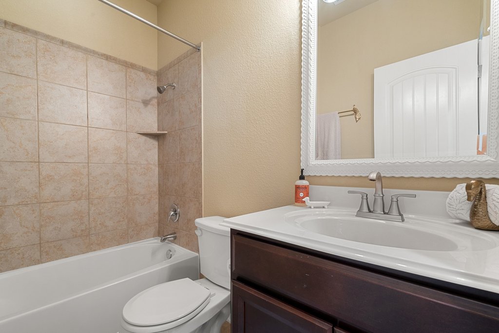 13808 Field Stream Lane Manor, TX 78653 - Photo 27 of 39 Bathroom featuring a textured wall, vanity, and shower / bath combination