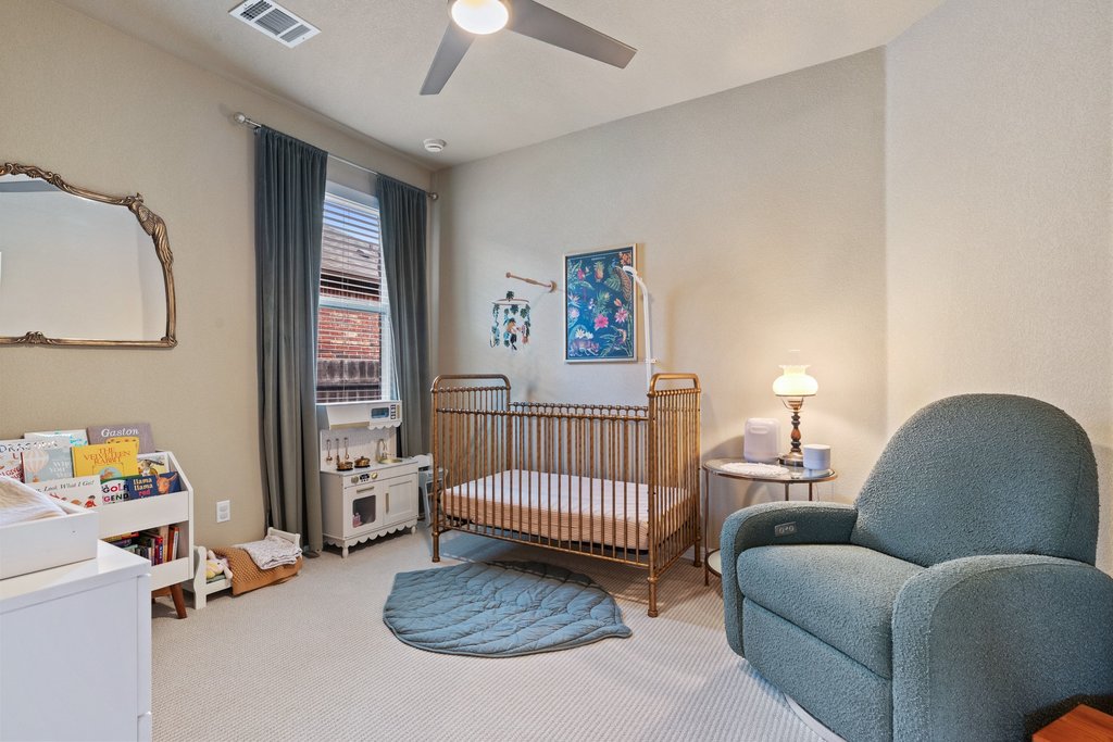 13808 Field Stream Lane Manor, TX 78653 - Photo 28 of 39 Bedroom with a crib, light colored carpet, and a ceiling fan
