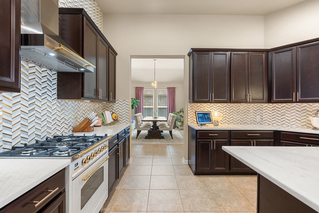 13808 Field Stream Lane Manor, TX 78653 - Photo 10 of 39 Kitchen featuring dark wood finish cabinets, high end white range, and light stone countertops