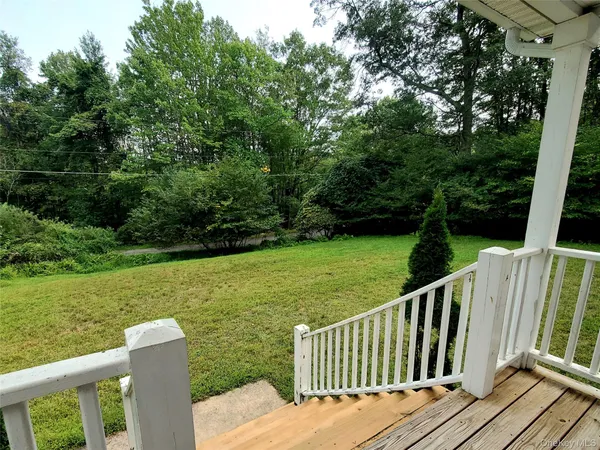 a view of a wooden deck and yard with green space