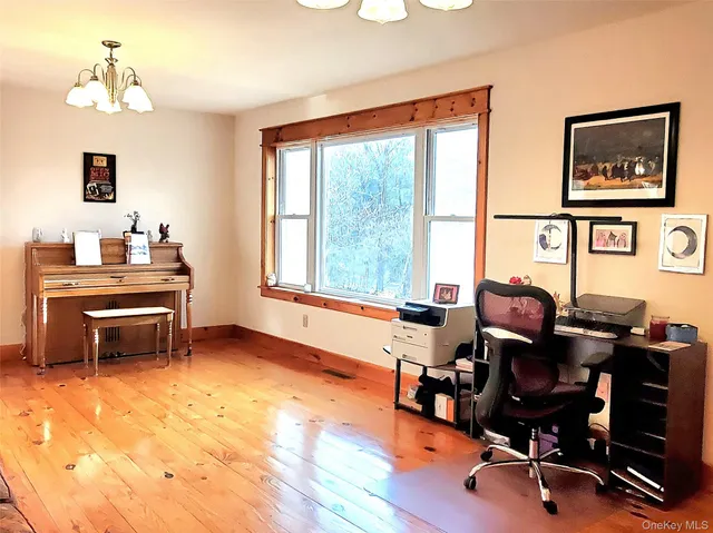 a view of a workspace with furniture and a window