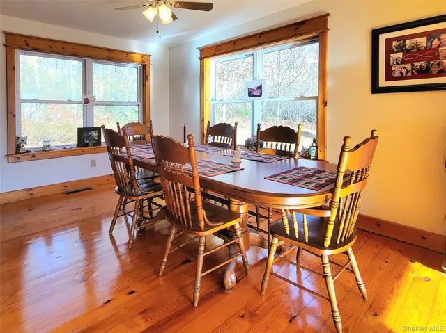 a dining room with furniture and wooden floor windows