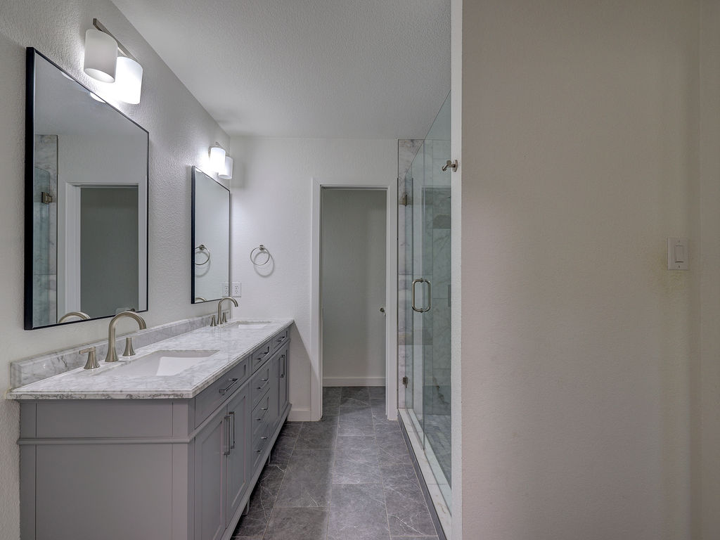 5842 Secrest Drive Austin, TX 78759 - Photo 32 of 40 Double vanity with elegant marble counters and sleek fixtures adorns this primary bathroom.