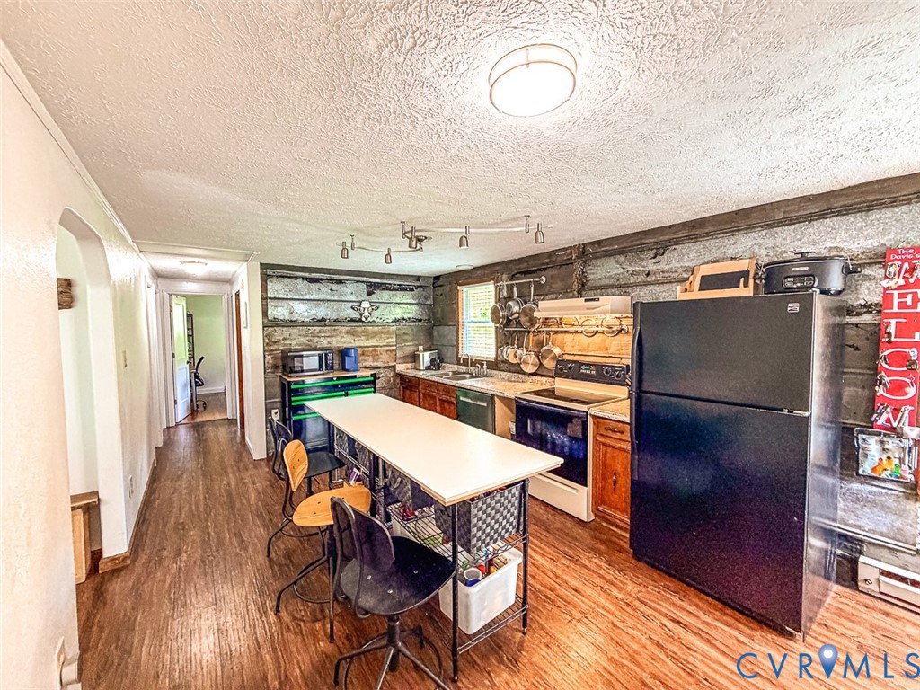 453 Long Hollow Road Cleveland, VA 24225 - Photo 14 of 50 a kitchen with stainless steel appliances a refrigerator a stove a sink dishwasher and a dining table with wooden floor