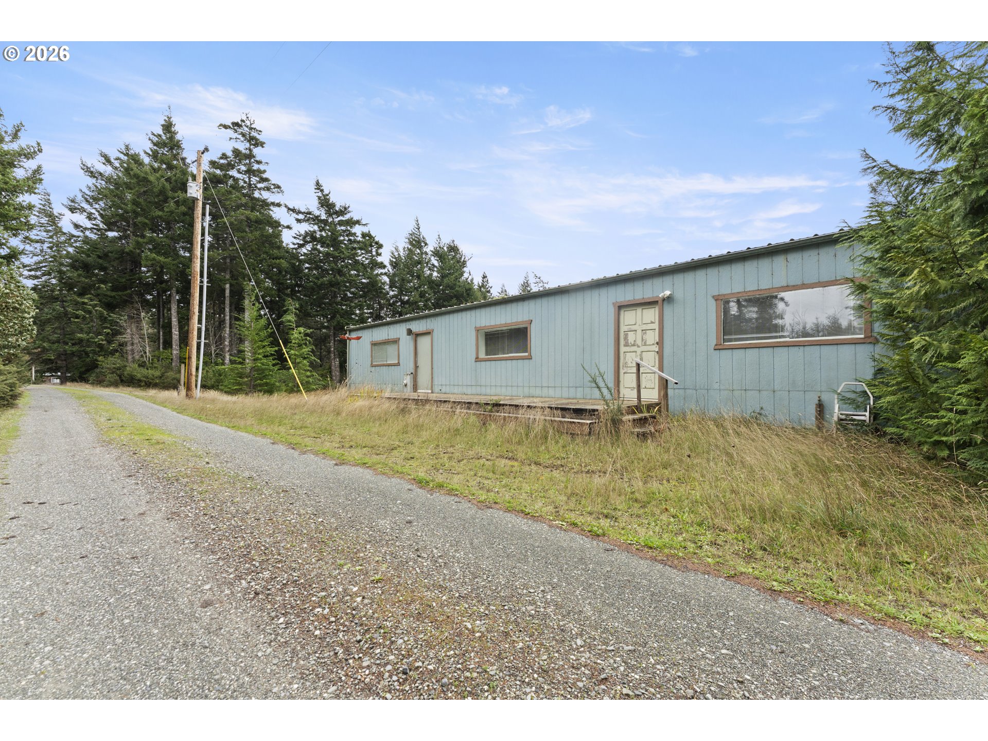 53665 Rosa Road Bandon, OR 97411 - Photo 5 of 47 a backyard of a house with table and chairs