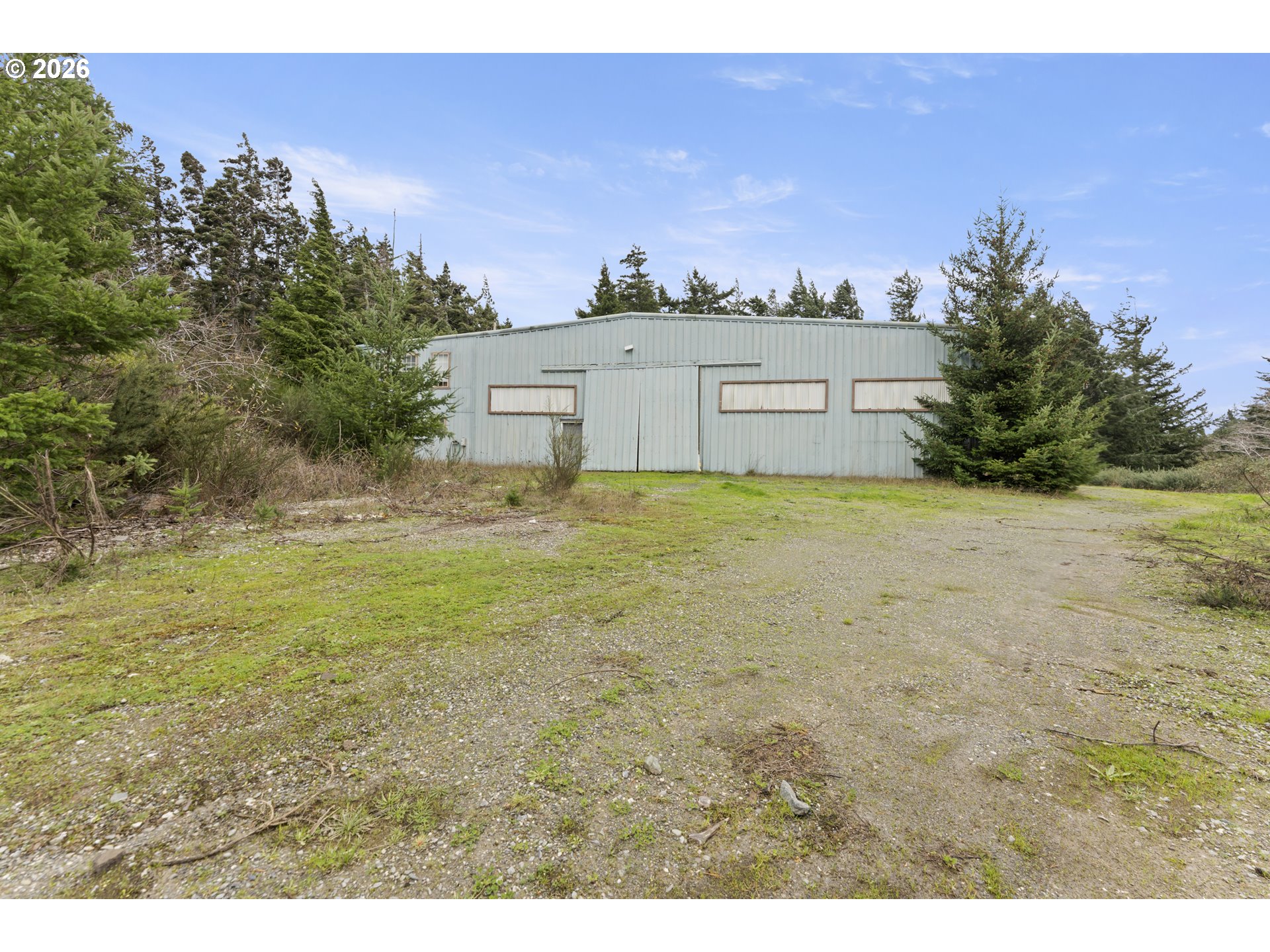 53665 Rosa Road Bandon, OR 97411 - Photo 6 of 47 a view of a big yard with a house in the background