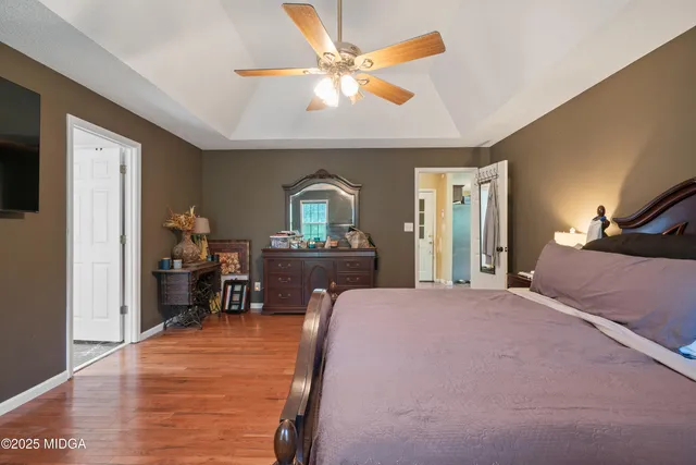 a bedroom with a bed and a dresser with mirror
