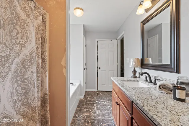 a bathroom with a granite countertop sink and a mirror
