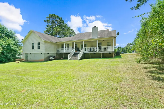 a view of a house with a yard and potted plants