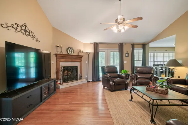a living room with furniture a flat screen tv and a fireplace