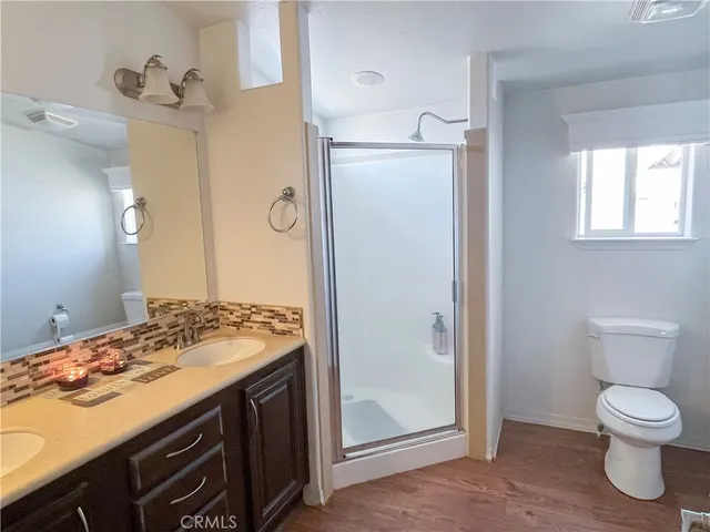 a bathroom with a granite countertop sink toilet and shower