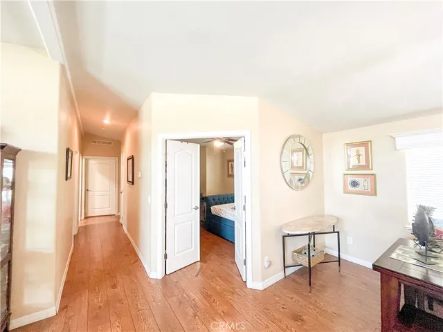 a view of a hallway with wooden floor and furniture