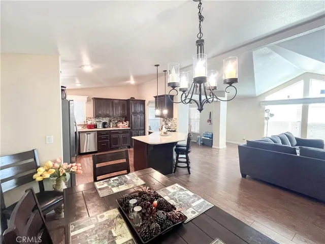 a living room with furniture kitchen view and a wooden floor