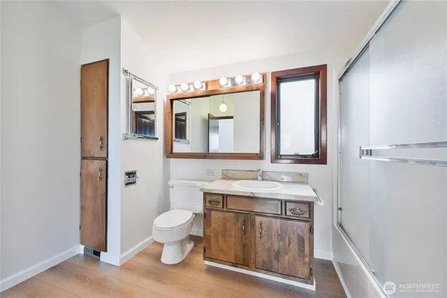 a bathroom with a granite countertop sink mirror and a toilet
