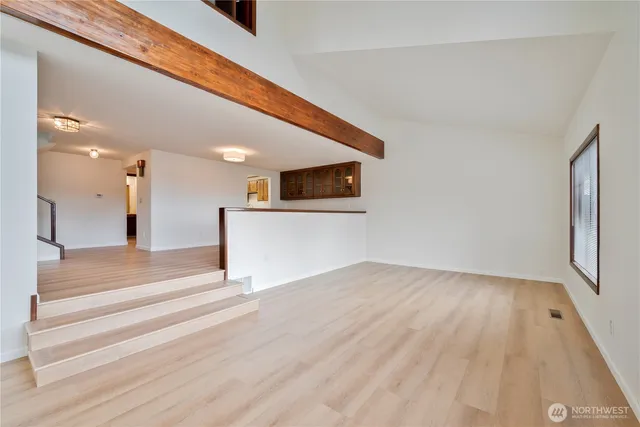 a view of a hallway with wooden floor and a large window