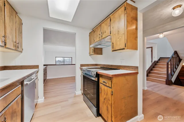 a kitchen with a stove and a wooden floor