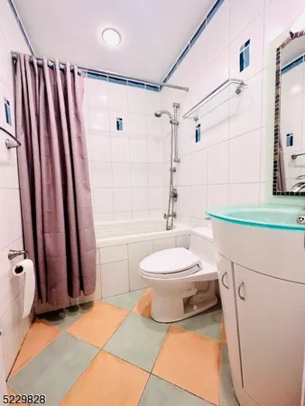 a bathroom with a sink a toilet a mirror and shower