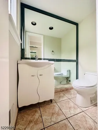 a bathroom with a granite countertop sink a toilet and a mirror