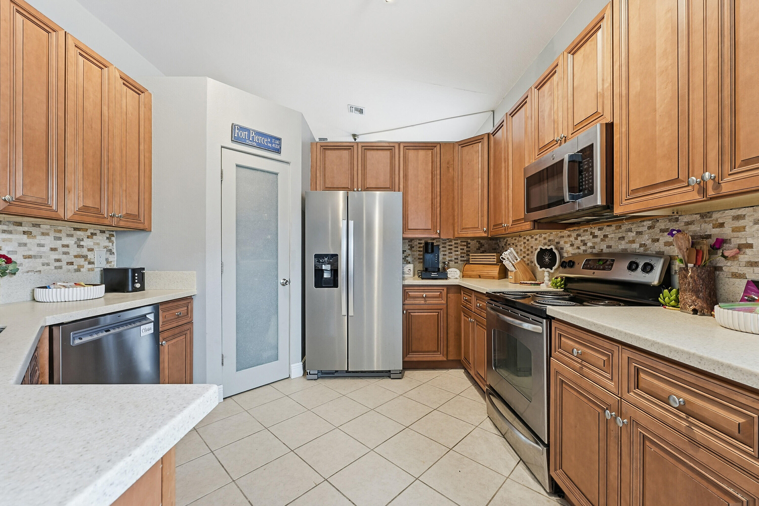 6117 Spring Lake Terrace Fort Pierce, FL 34951 - Photo 14 of 38 a kitchen with stainless steel appliances granite countertop a refrigerator stove top oven and sink