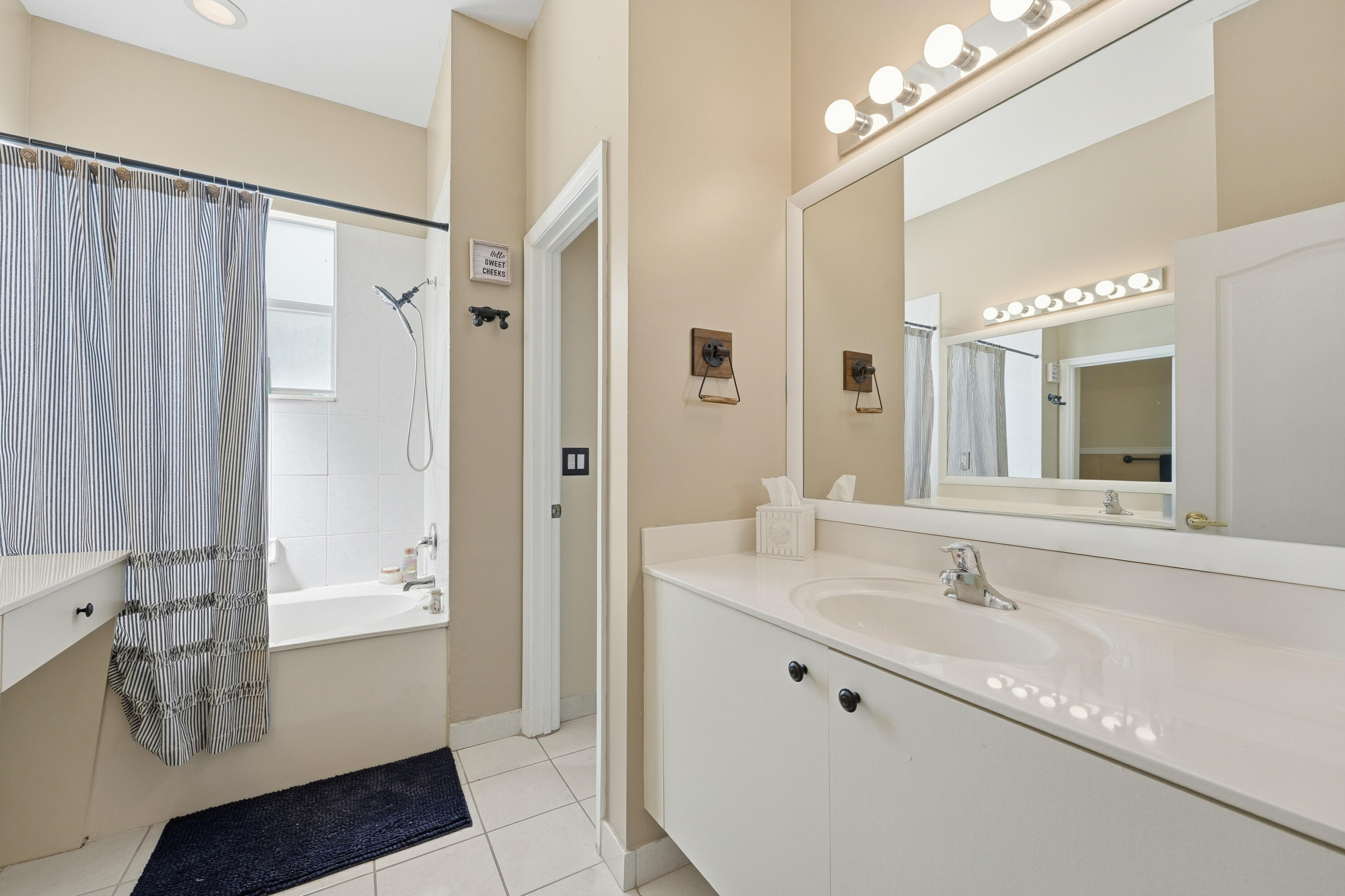 6117 Spring Lake Terrace Fort Pierce, FL 34951 - Photo 22 of 38 a bathroom with a double vanity sink a mirror and a bathtub