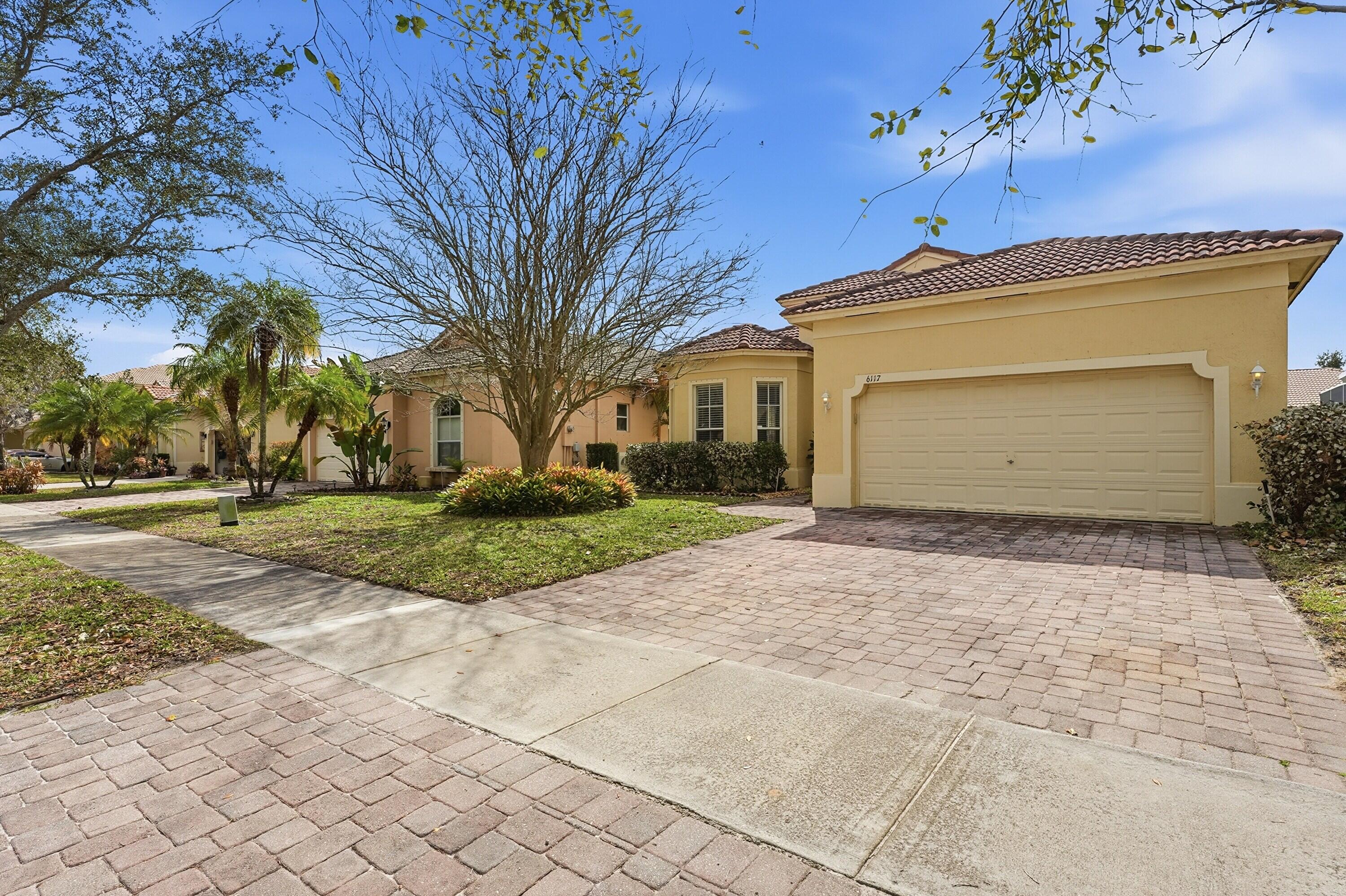 6117 Spring Lake Terrace Fort Pierce, FL 34951 - Photo 3 of 38 a front view of a house with a yard and garage
