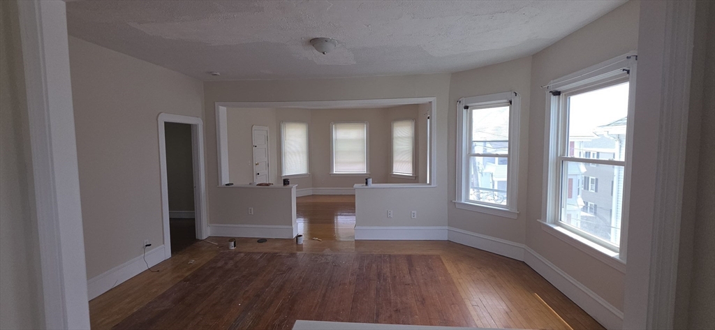 105 6th Street, Unit 3 Fall River, MA 02721 - Photo 8 of 10 wooden floor in an empty room with a window