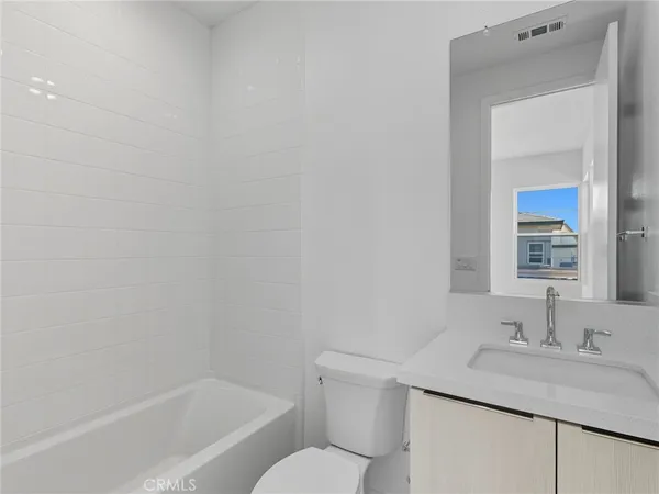 a bathroom with a granite countertop sink toilet and mirror