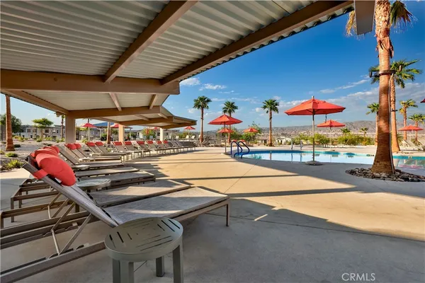 an outdoor space with patio couches table and chairs under an umbrella