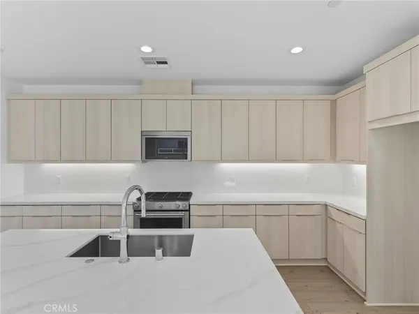 a kitchen with granite countertop a stove a sink and a microwave