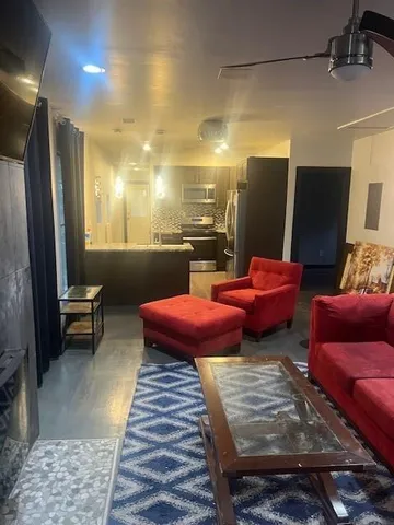 a living room with furniture a flat screen tv and a table