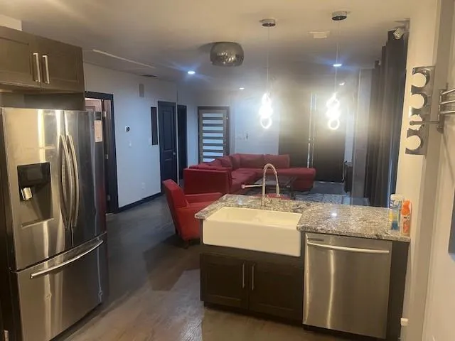 a kitchen with stainless steel appliances granite countertop a refrigerator and a stove