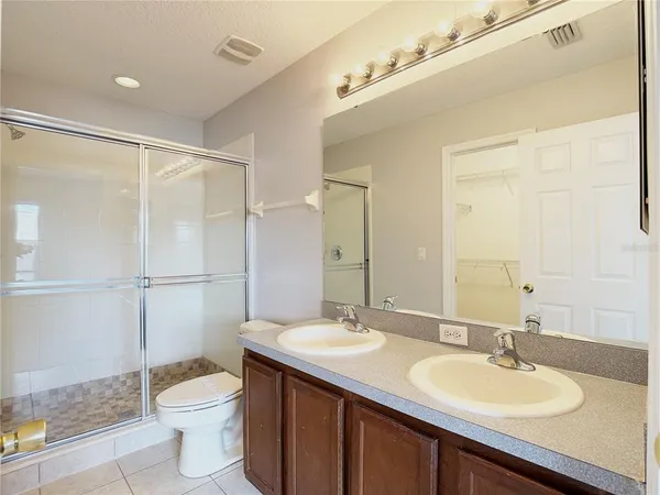 a bathroom with a sink a toilet a mirror and shower