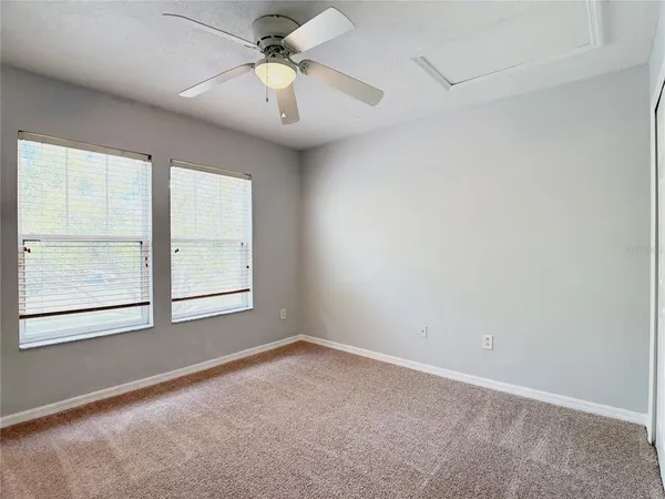 an empty room with a window and a fan
