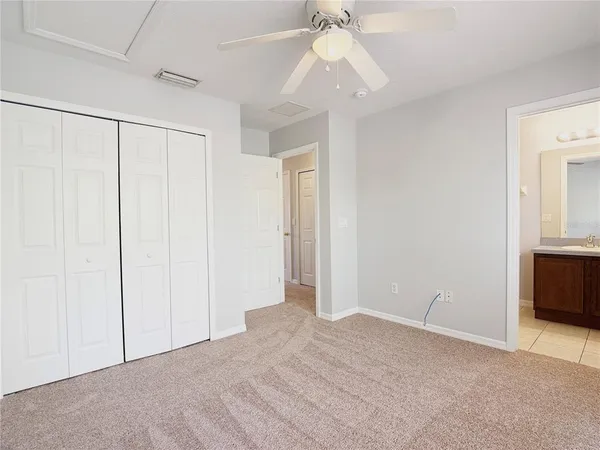 a view of an empty room with a chandelier fan