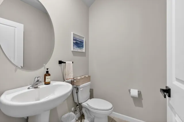 a bathroom with a sink a toilet and mirror