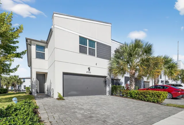 a front view of a house with a garden and garage
