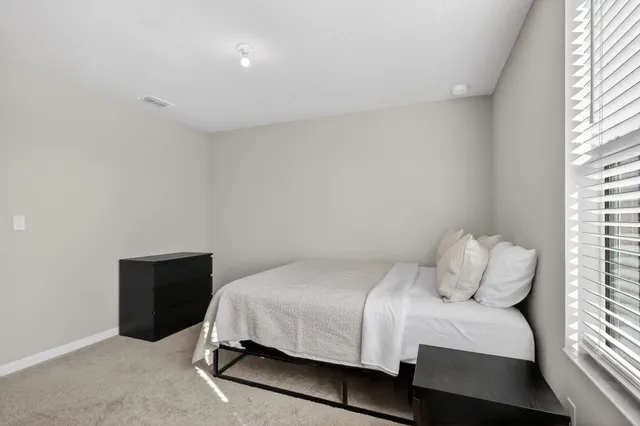 a bedroom with a bed and window