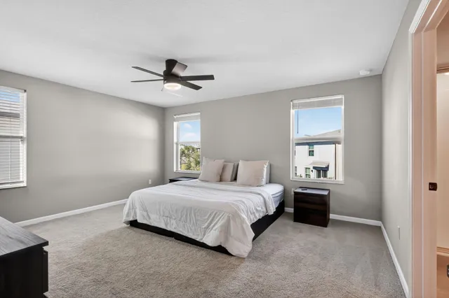 a bedroom with a bed and a ceiling fan